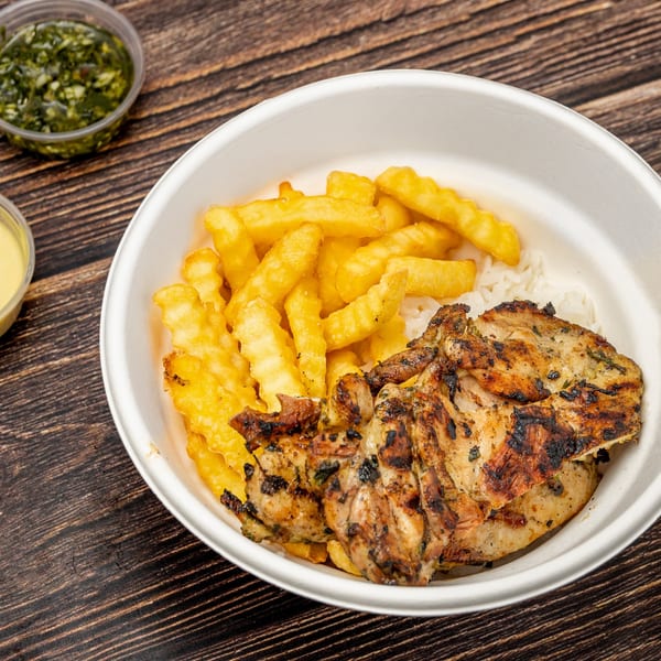 Picaso Chicken's grilled chicken and crinkle-cut fries with rice in a white bowl, with sauces.