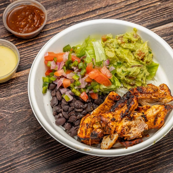 Picaso Chicken's grilled chicken bowl with rice, black beans, pico de gallo, guacamole, and lettuce.
